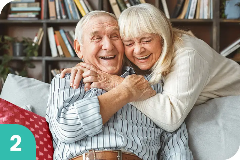 A senior couple embracing each other on a couch