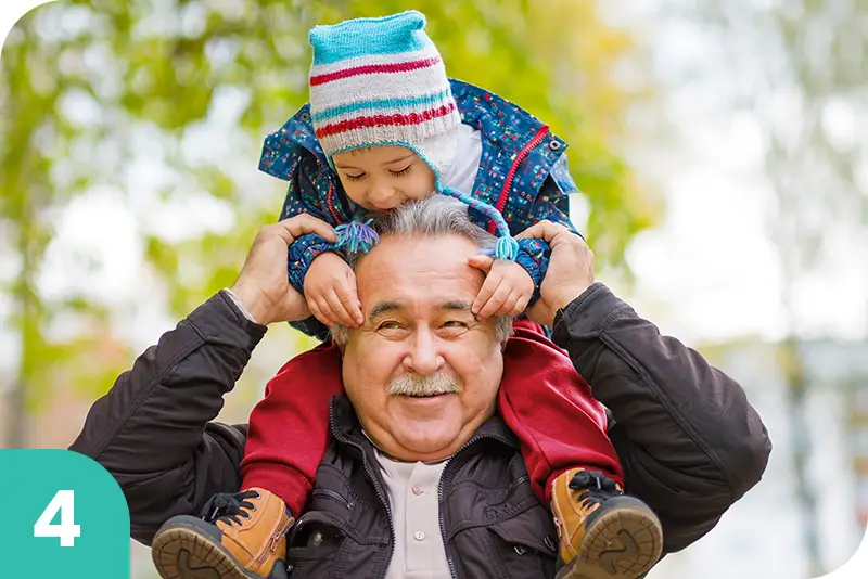 A grandfather holding his grandson on his shoulders