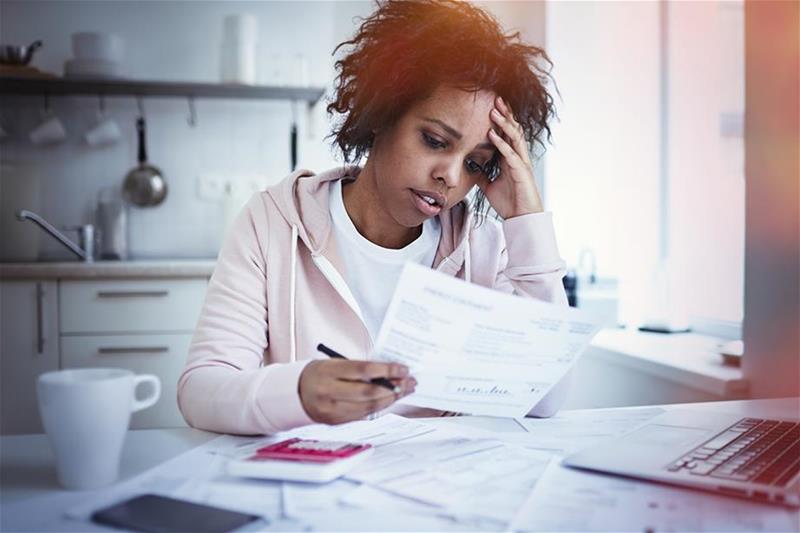 Young woman looking at paperwork with concern