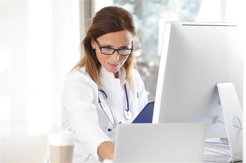 Female doctor working on tablet and laptop