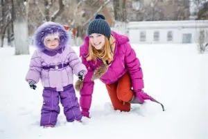 A mom and toddler playing in the snow