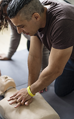 Man practicing CPR on a dummy