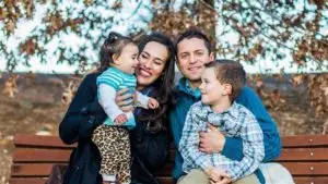 A family of four sitting on a bench