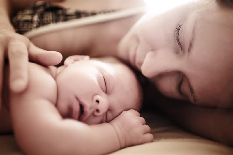 Mamá y bebé tumbados en una cama