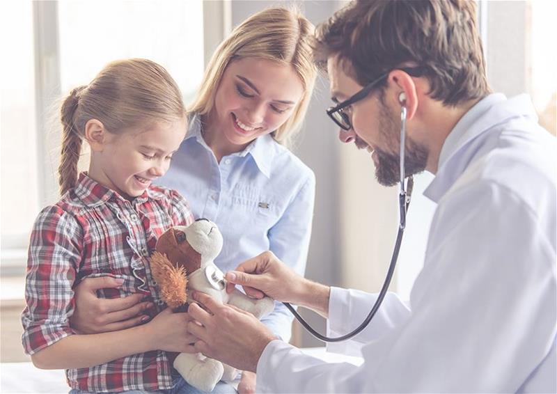 A doctor checking the heartbeat of a stuffed animal dog