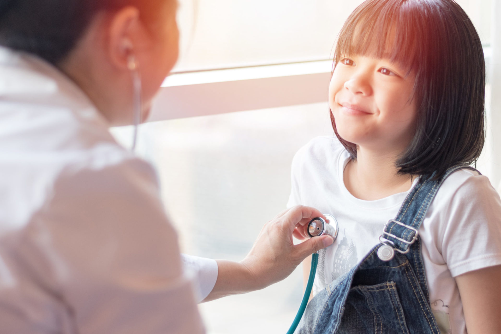 Doctor takes a young girls heartbeat with a stethoscope