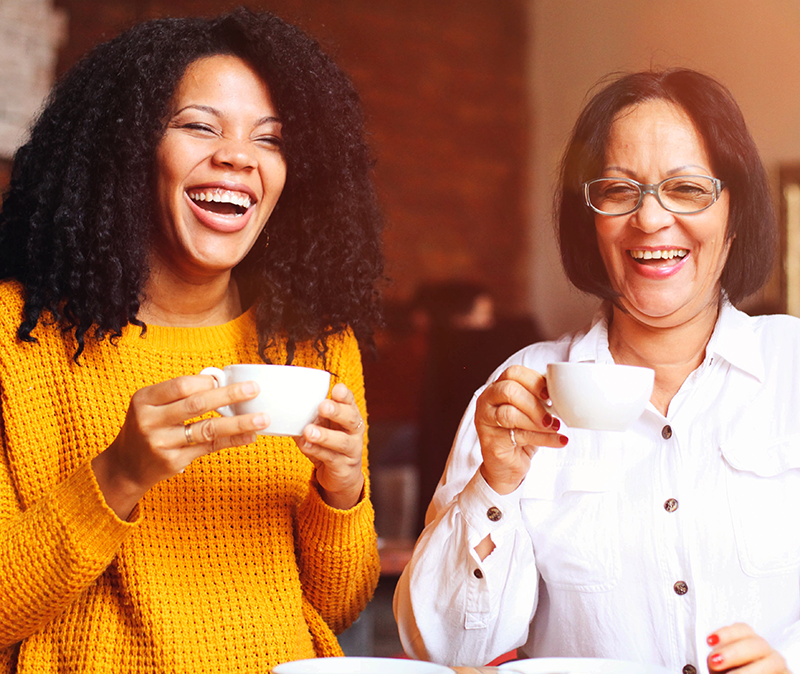 Madre e hija comparten un momento divertido mientras toman un café
