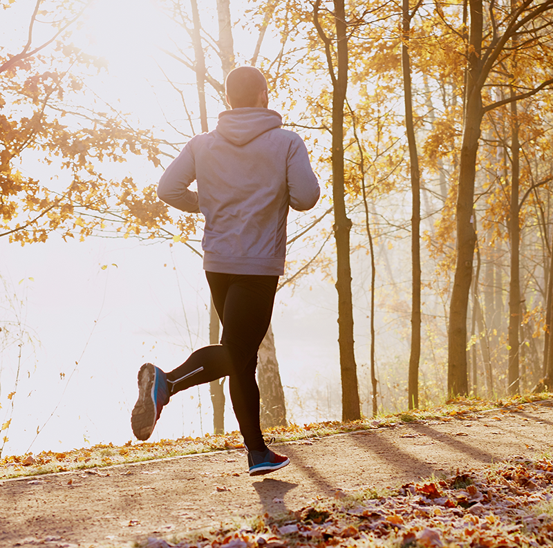 Man jogging on a wooded path in fall