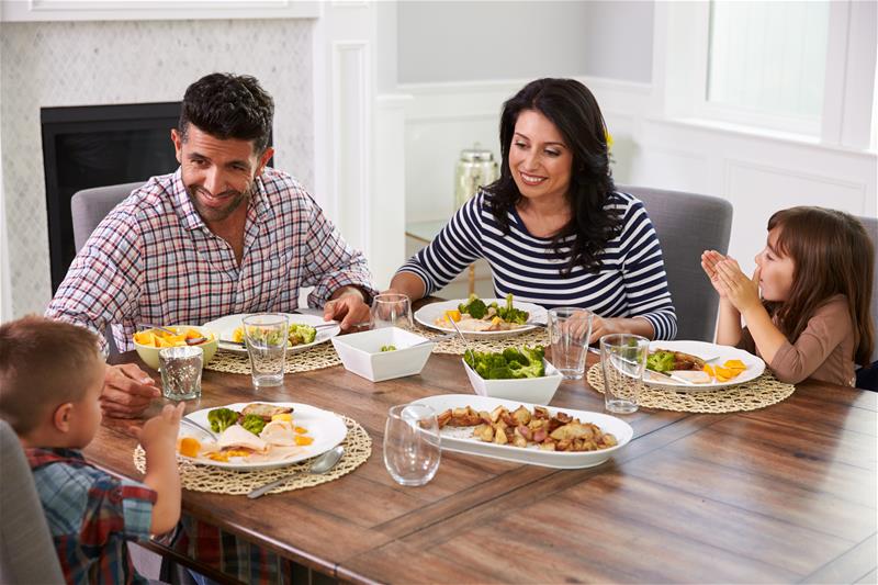 Family of four sitting down to a healthy dinner