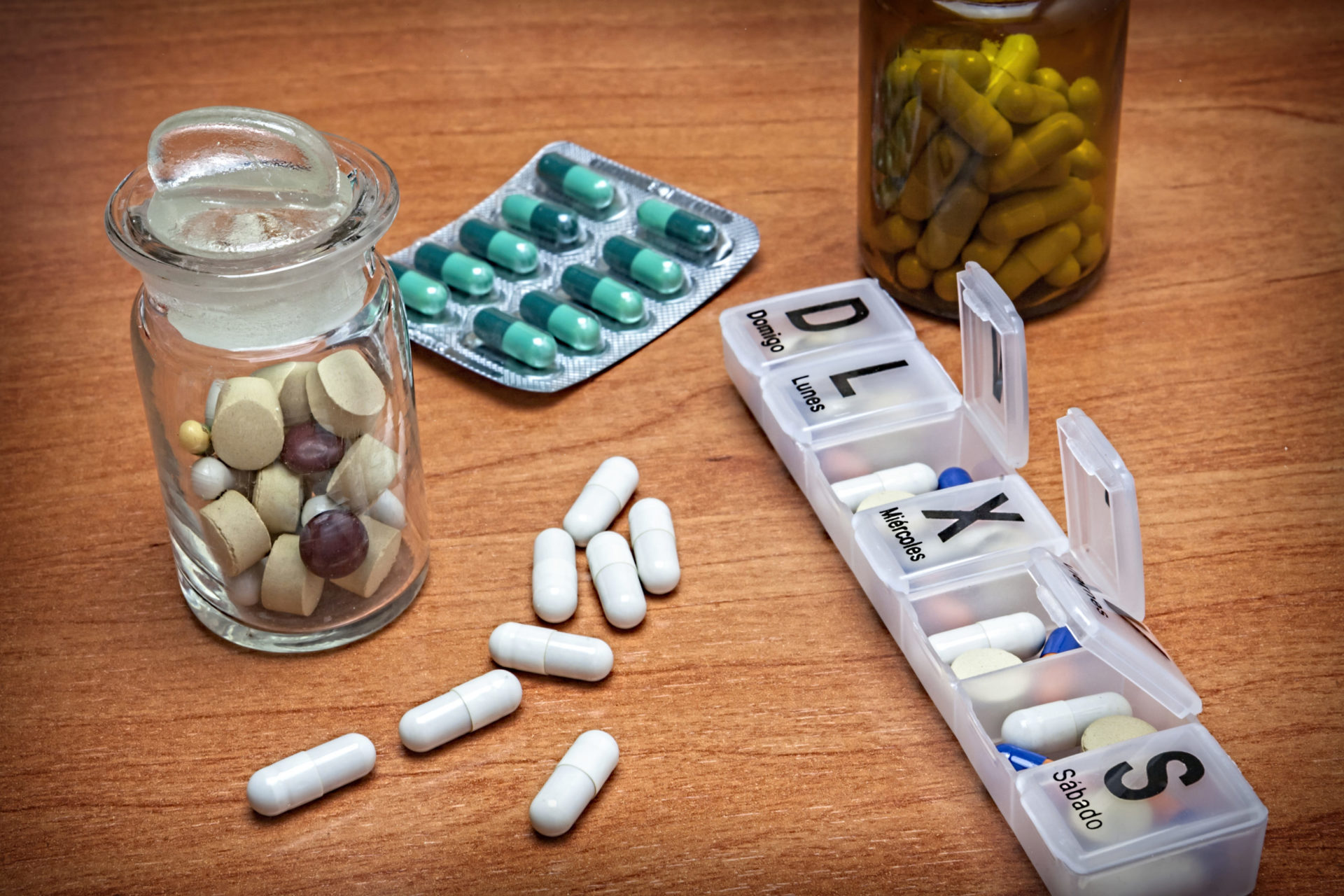 Contenedores de píldoras que rodean un pastillero semanal