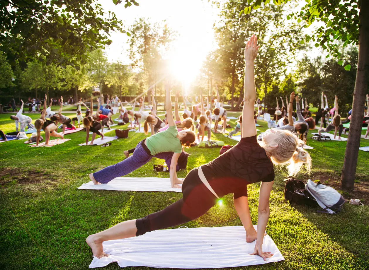A group of people participating in an outdoor yoga class