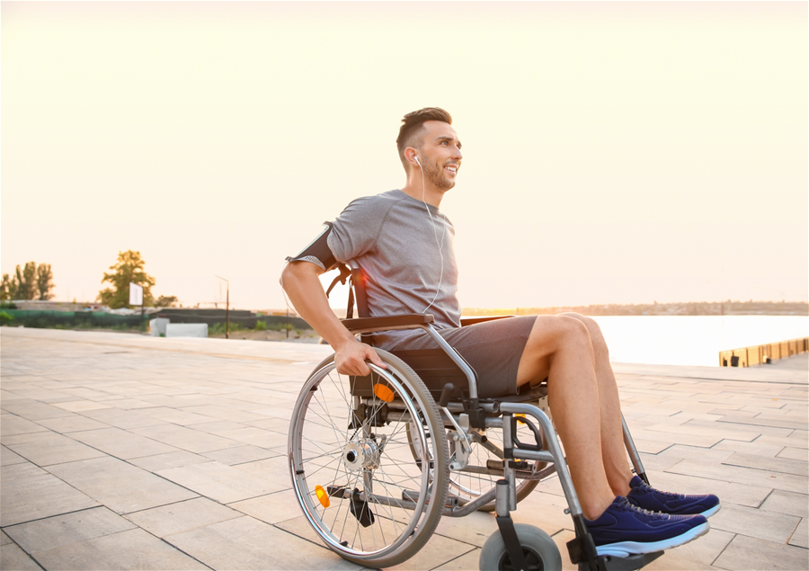 Young man in a wheelchair listening to music