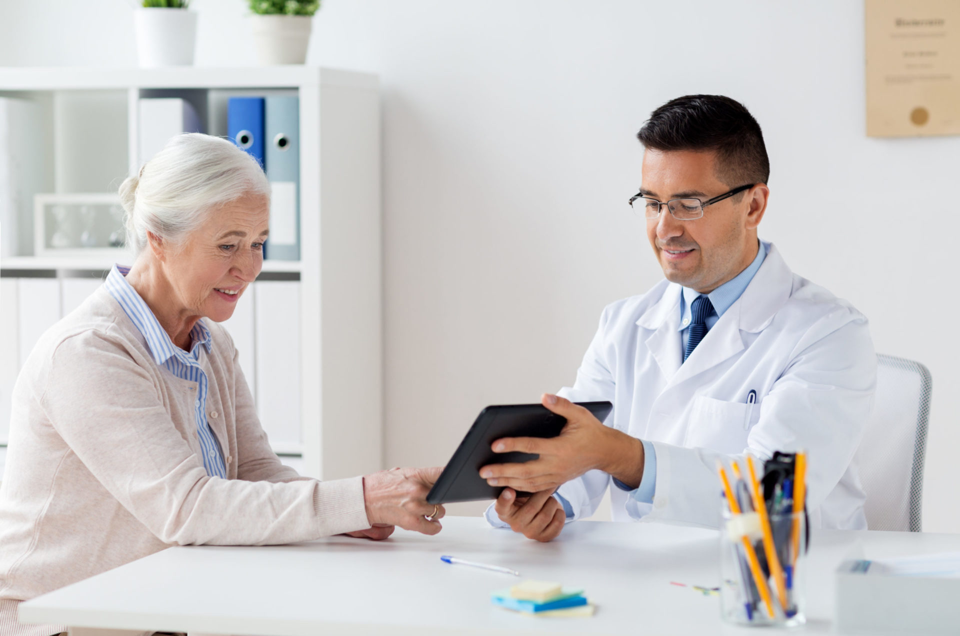 Doctor showing tablet to senior woman in his office
