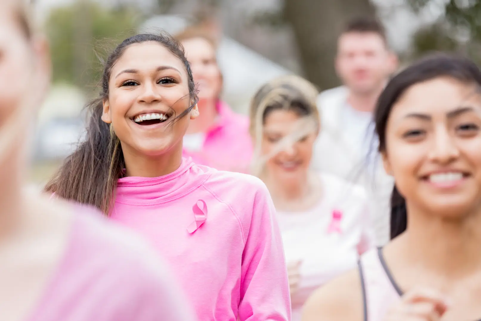 A group of individuals wearing pink participating in a breast cancer awareness race