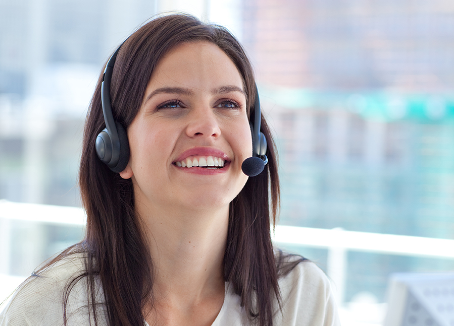 Customer service representative smiles while talking on a headset