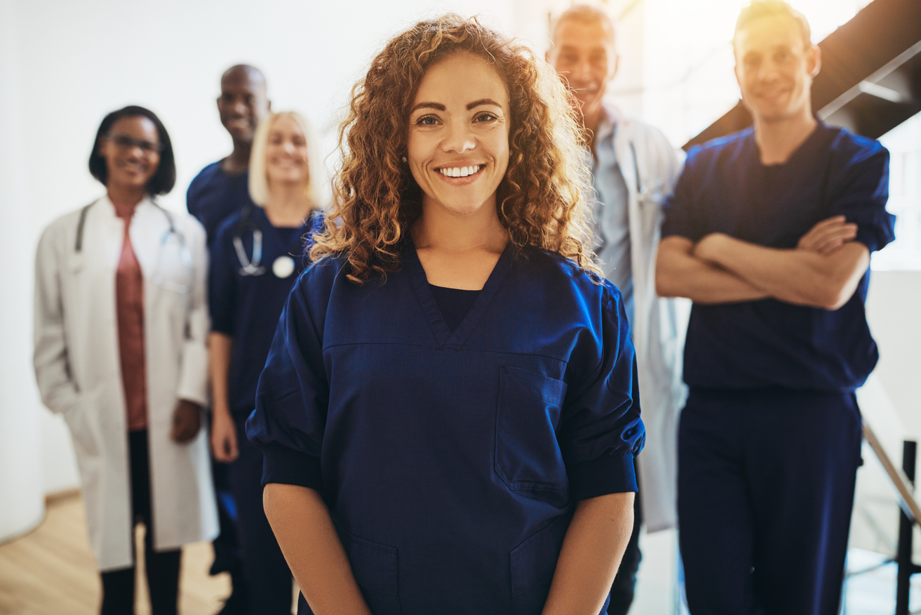 Un grupo diverso de trabajadores de la salud posando y sonriendo