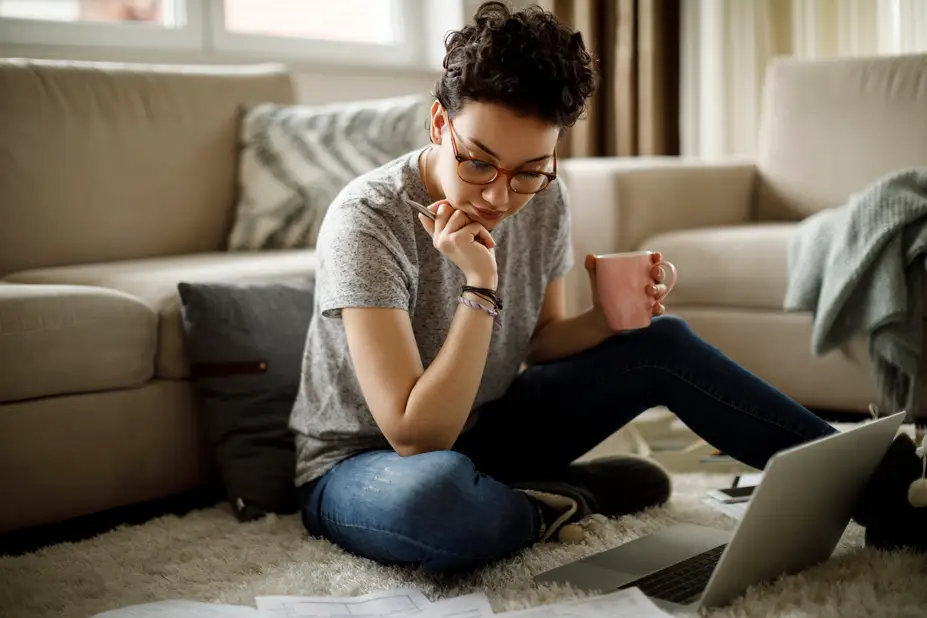 A student goes over homework while holding a cup of coffee