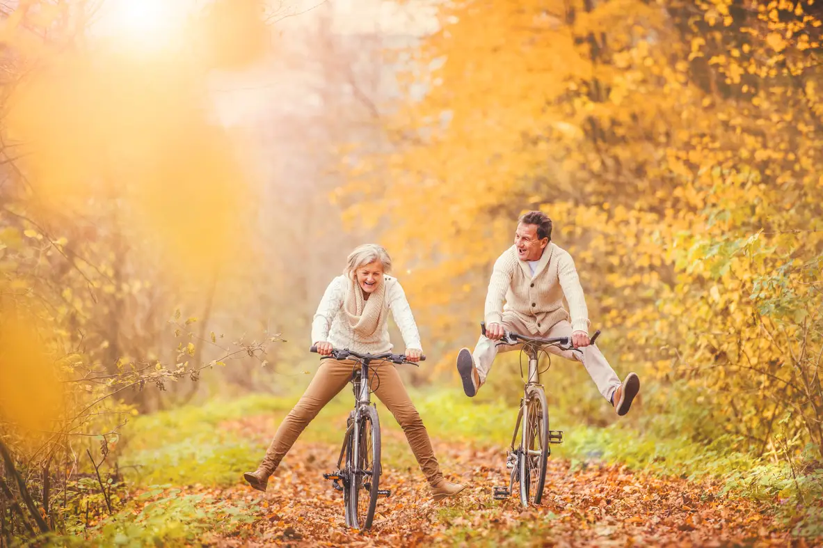 A senior couple having fun on bikes on an autumn day
