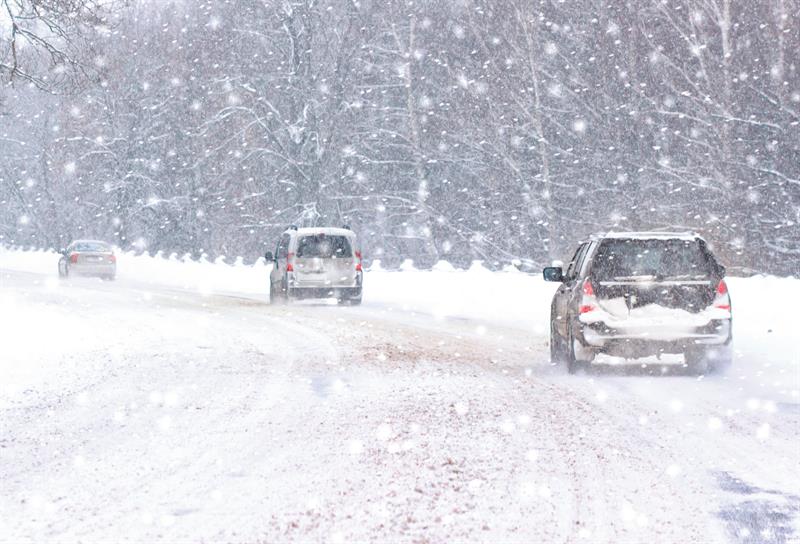 Vehicles on the road in heavy snow