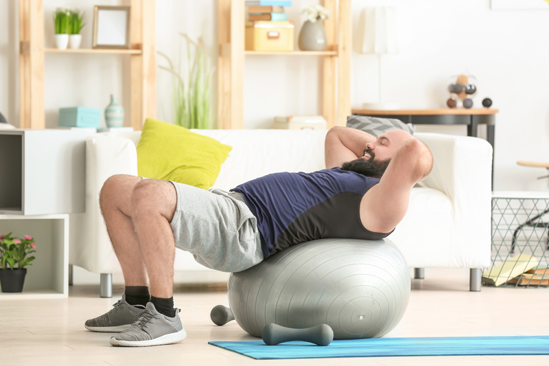 Man works out on an exercise ball at home