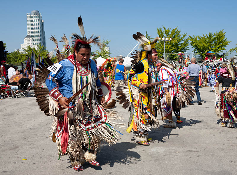 Native American dancers in traditional outfits during the Pow Wow tribal dance