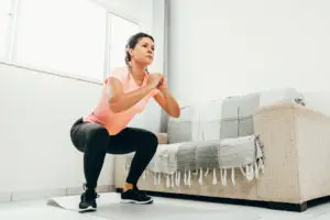 A woman doing squats in her apartment