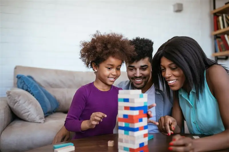 A family of three playing with blocks together