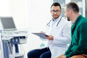 A doctor consulting with a male patient in the exam room