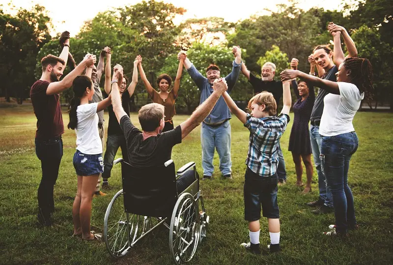 A group of diverse in a circle with arms raised together