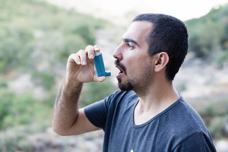 Young man using an inhaler