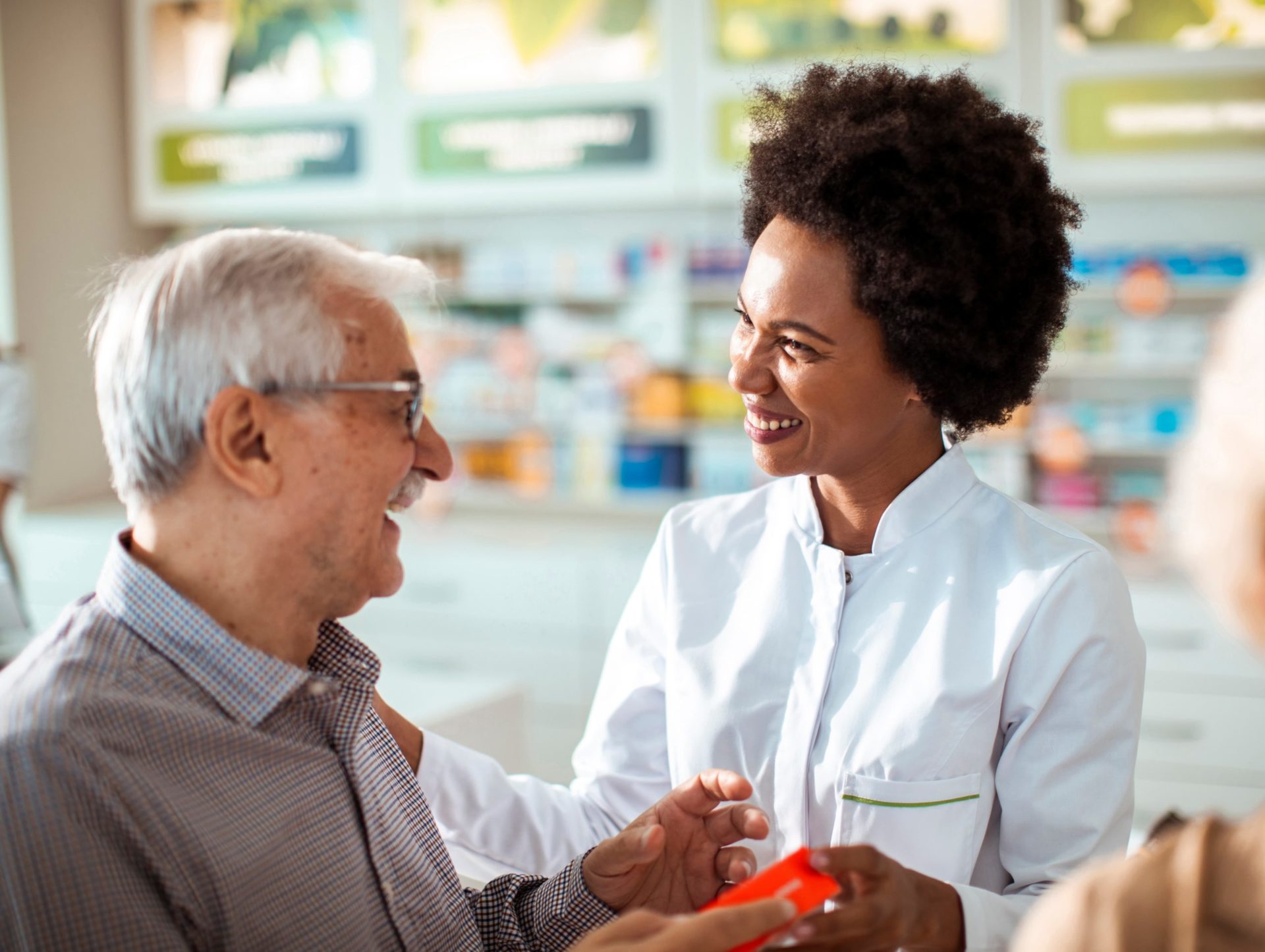 A pharmacist talks to senior man