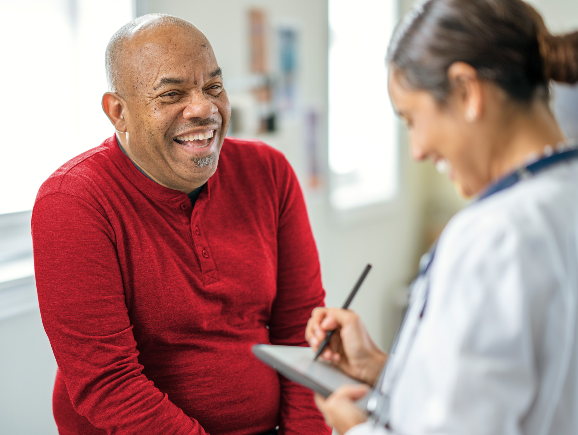 A woman giving a senior man a check up appointment