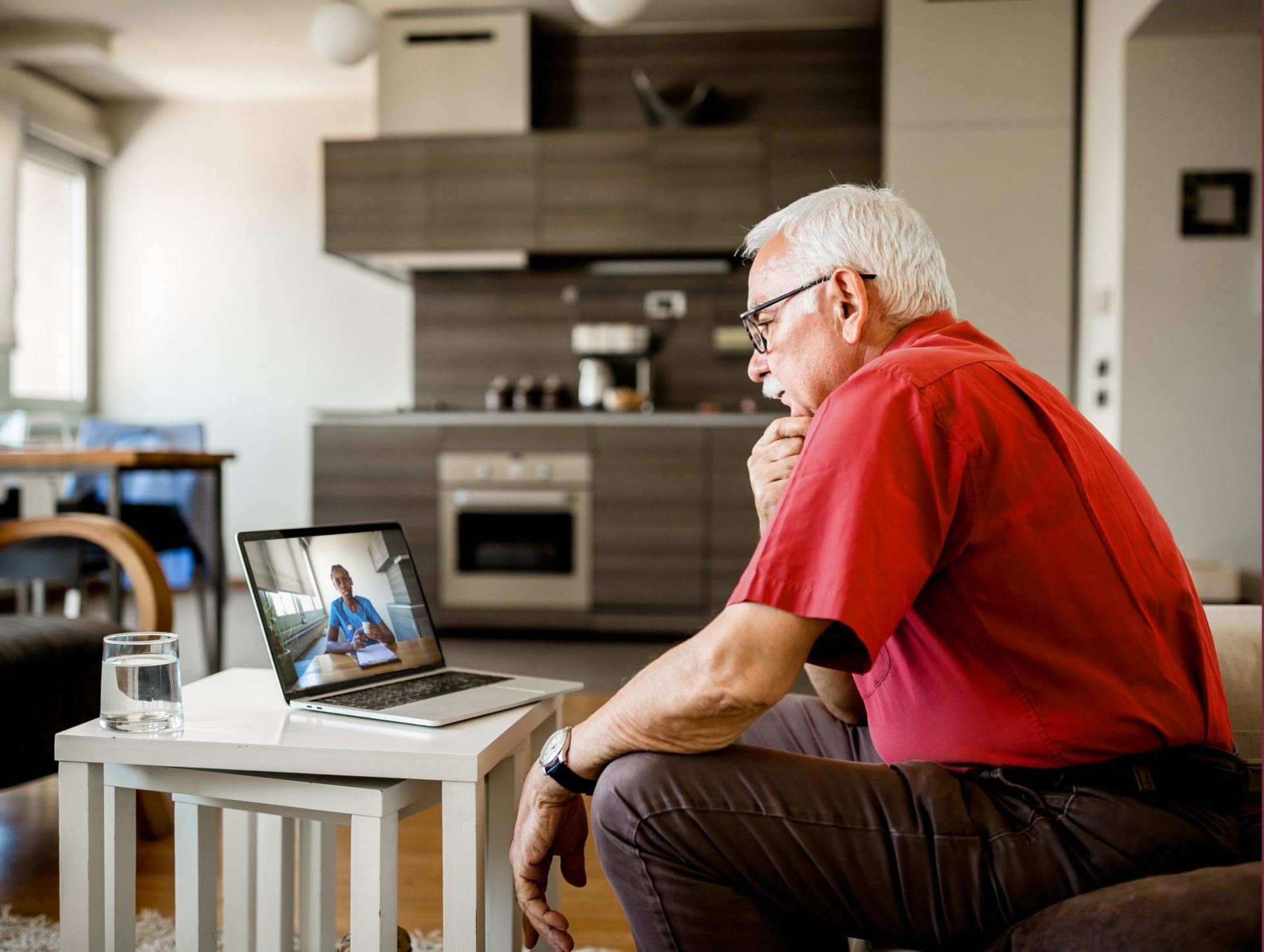 A senior man on a virtual visit from his laptop with his doctor