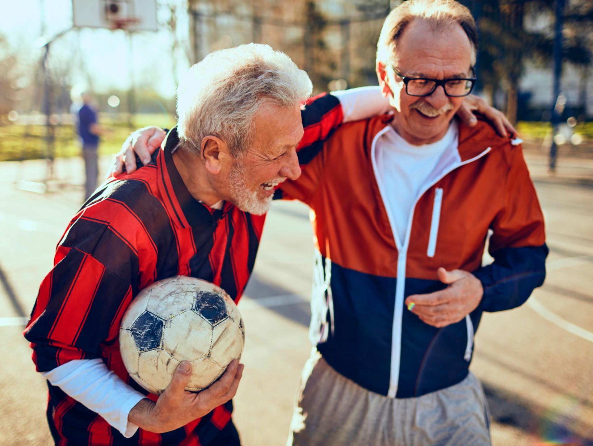 Senior men laugh as they play soccer