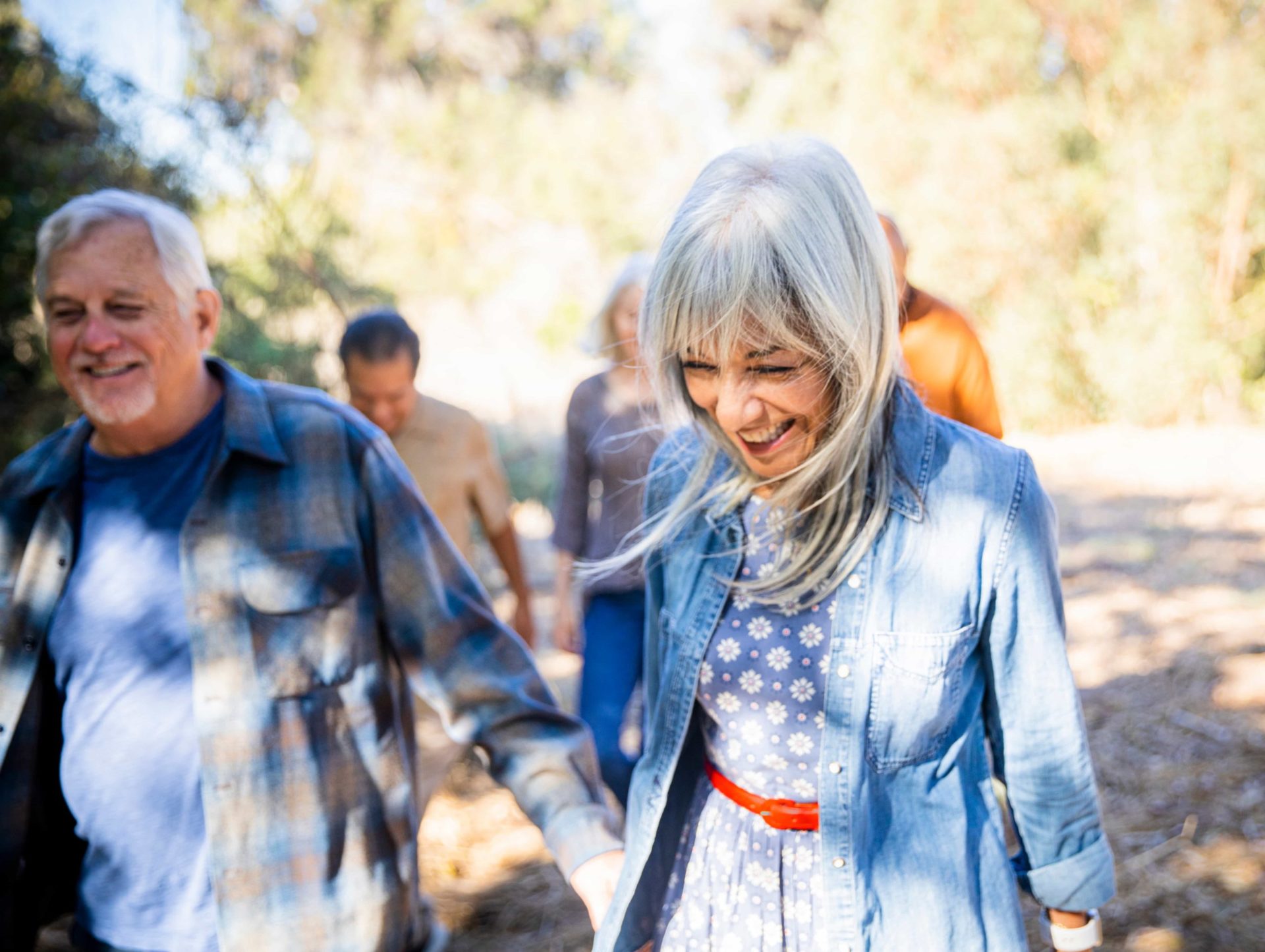Mujer mayor caminando con un grupo de otras personas mayores en el exterior