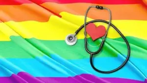 An LGBTQ flag with a heart and stethoscope