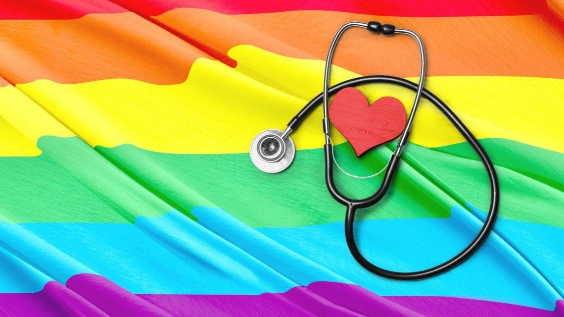 An LGBTQ flag with a heart and stethoscope