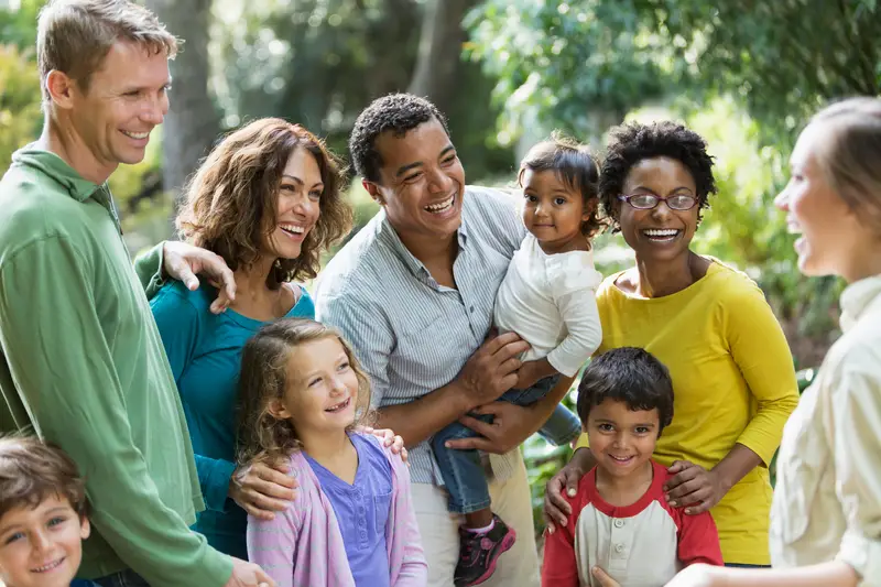 A diverse group at a park talking with a tour guide