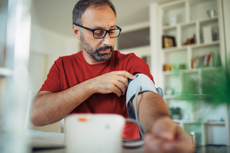 A man using a blood pressure cuff at home