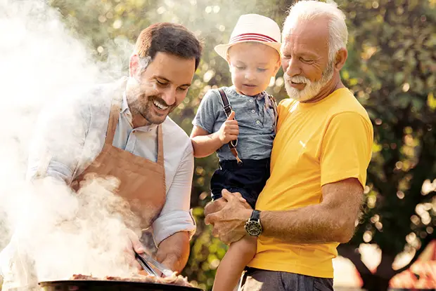 A multi-generational family of men at a cook-out