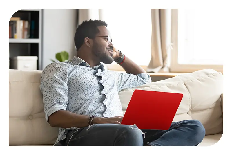 A man sitting on a couch using a laptop