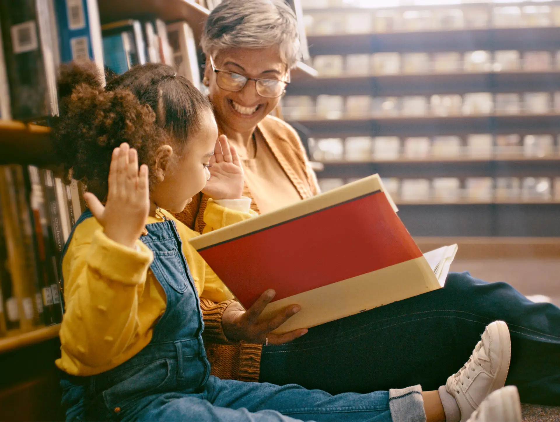 Un profesor leyendo a un alumno en una biblioteca