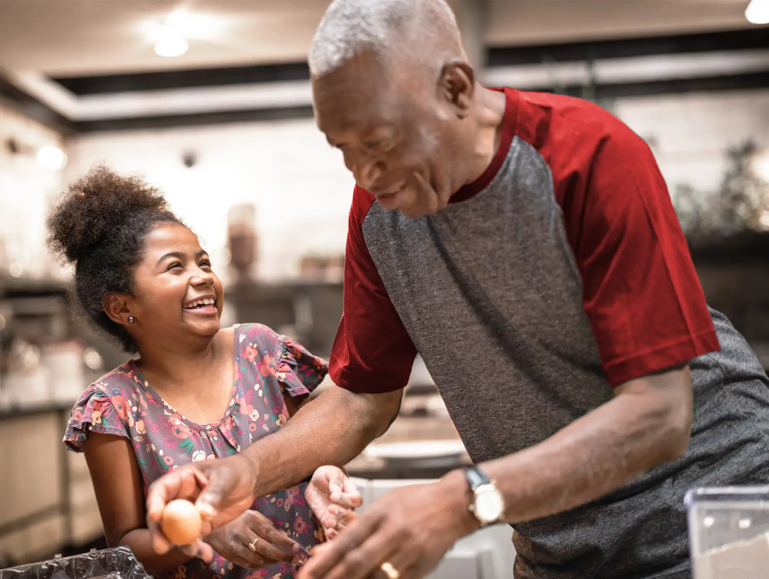 A senior man cooking with a young girl