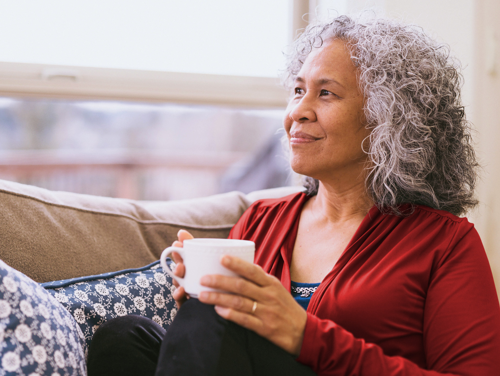 Senior woman relaxing on the couch with a cup of tea