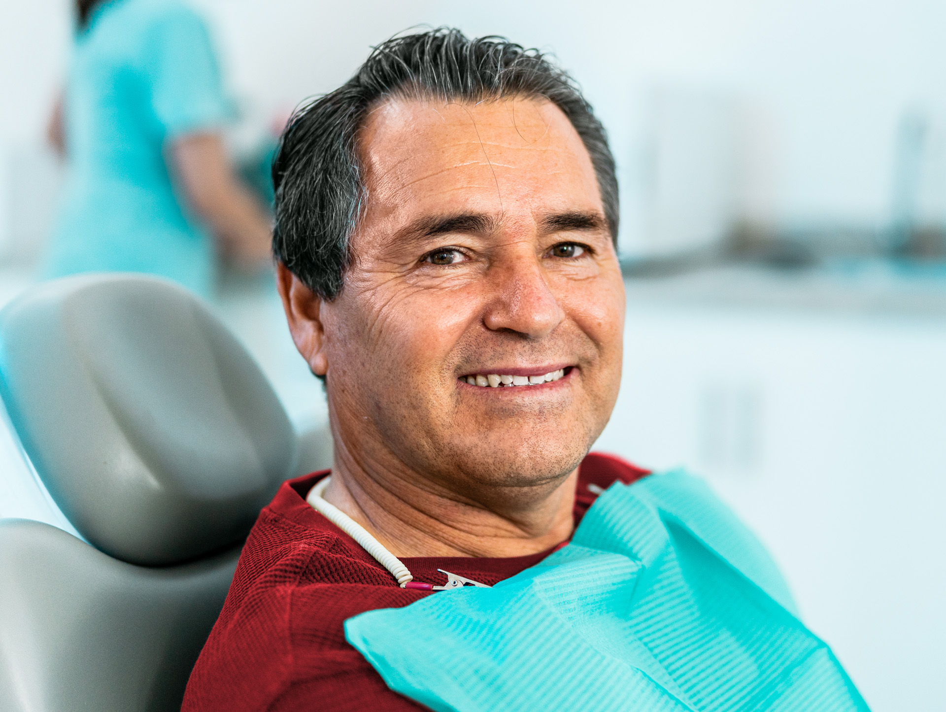 A man smiling while in a dentist chair