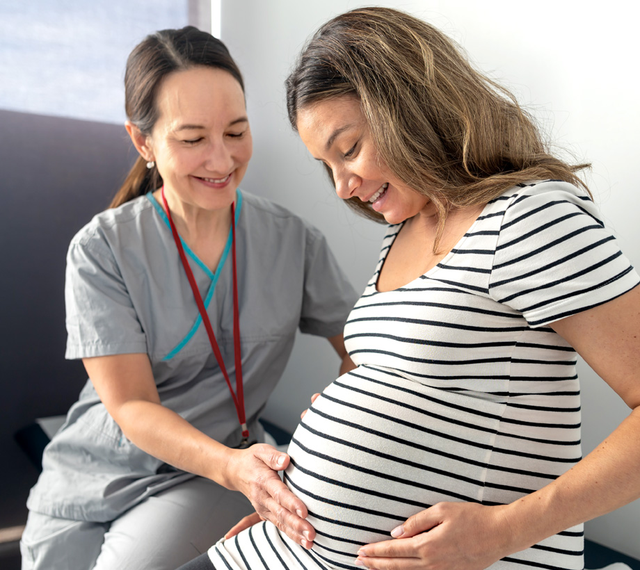 A healthcare professional checks on a pregnant mother's belly
