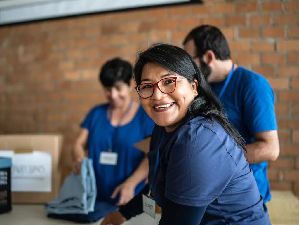 Persona voluntaria en un centro de donación de ropa.
