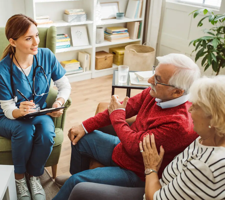 A doctor consults two patients at an at-home care visit.