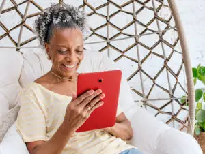 A senior woman reading information on a tablet