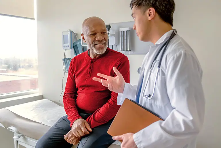 A person sits with a smile while speaking with a health professional